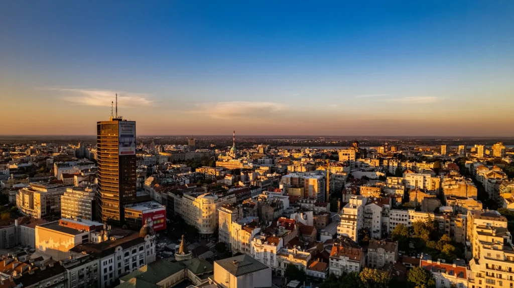 Belgrade rooftops at sunset with the Danube on the horizon