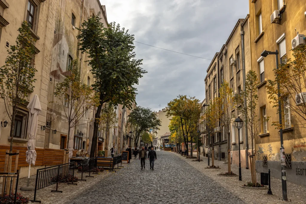 Cobbled street in Skadarlija lined with trees in autumn colour